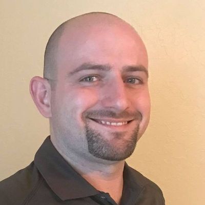 Headshot of Tristan Sheafer Software Engineer with Ridiculous Engineering, smiling and wearing a blue shirt, with short dark hair.