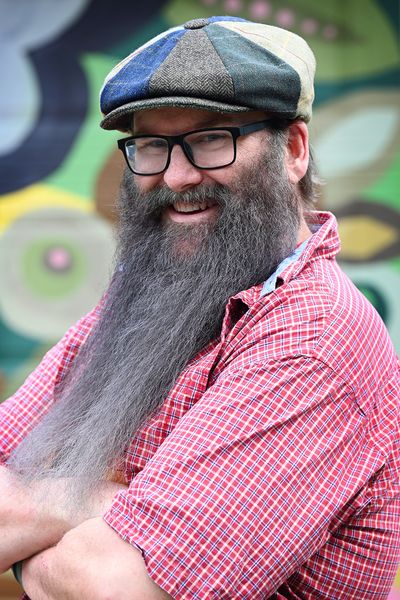 Headshot of Patrick Lanigan CTO of Ridiculous Engineering, wearing glasses, a cap, and a red checkered shirt, with a long beard and a friendly smile.