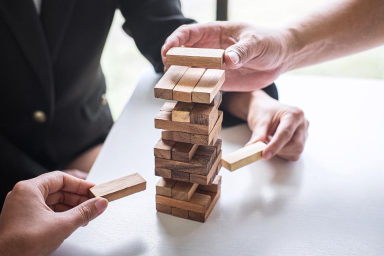 Two hands playing jenga on a table