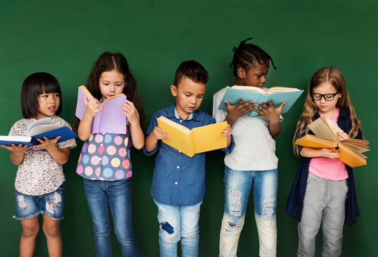 A group of diverse children reading books representing the importance of literacy