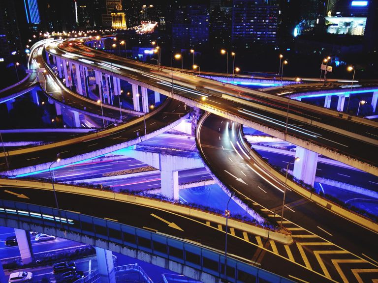 multiple car bridges light from underneath with blue light and from the top with yellow light.