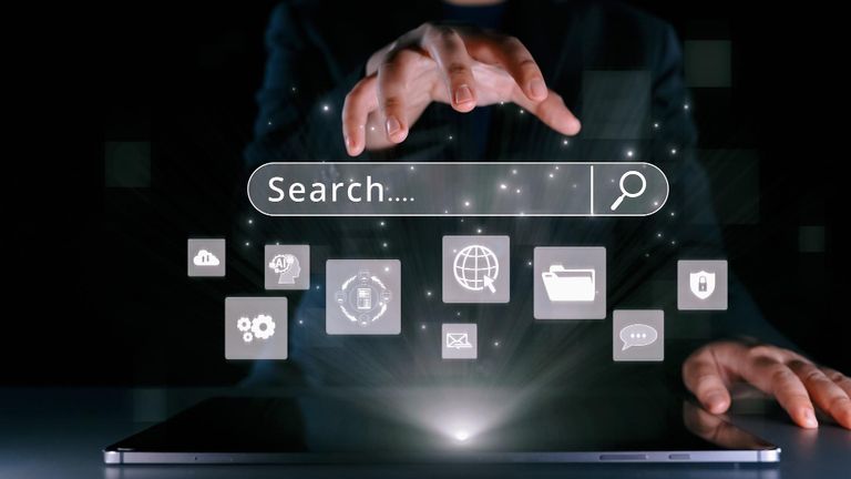 A light from below hand floating over a search box interface and various icons beneath the search interface.